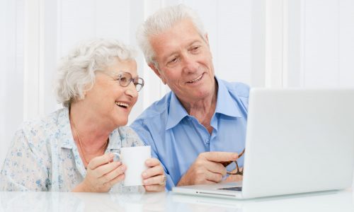 Happy elder couple enjoy together at laptop computer